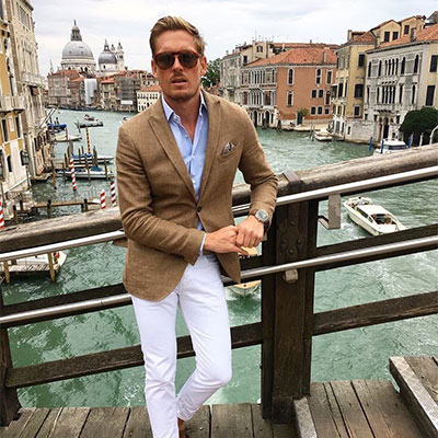 A man standing on a bridge beside a canal in Venice